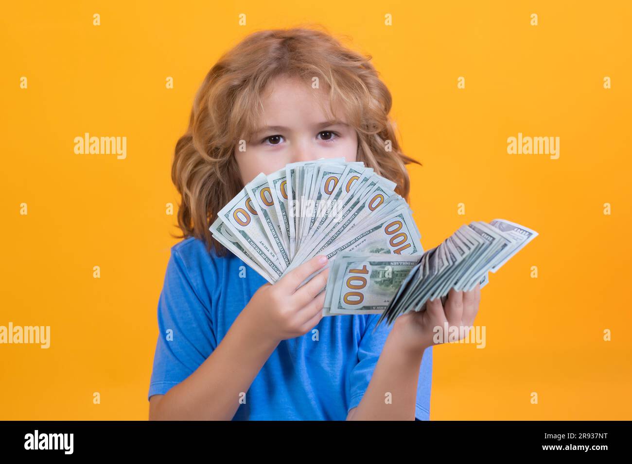 Der Junge hat viele hundert Dollar isoliert auf gelbem Hintergrund. Stockfoto