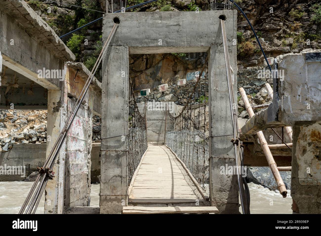 Fußgängerbrücke aus Holz und Stahlseilen über einem Fluss Stockfoto