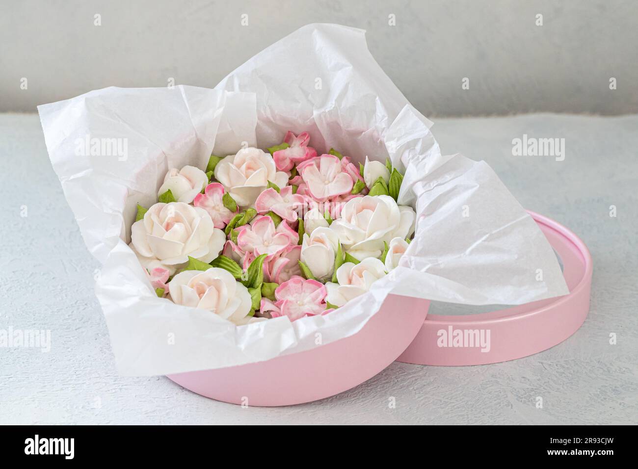 Zephyr-Blumenstrauß in einer Geschenkbox auf hellem Hintergrund. Stockfoto