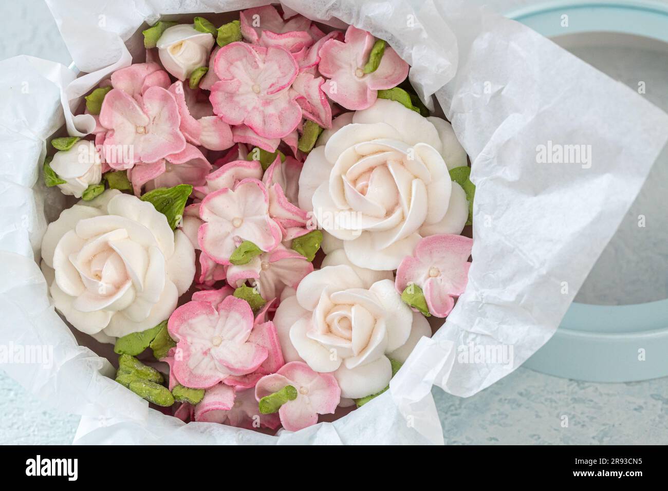 Zephyr-Blumenstrauß in einer Geschenkbox auf hellem Hintergrund. Stockfoto