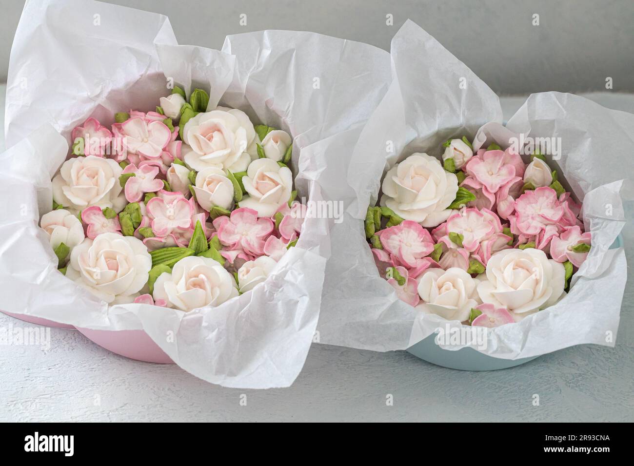 Zephyr-Blumenstrauß in einer Geschenkbox auf hellem Hintergrund. Stockfoto