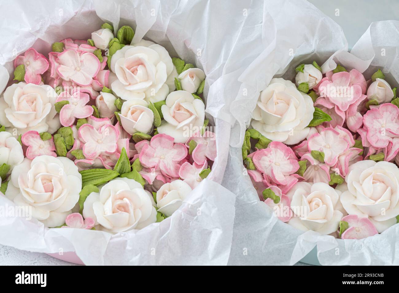 Zephyr-Blumenstrauß in einer Geschenkbox auf hellem Hintergrund. Stockfoto