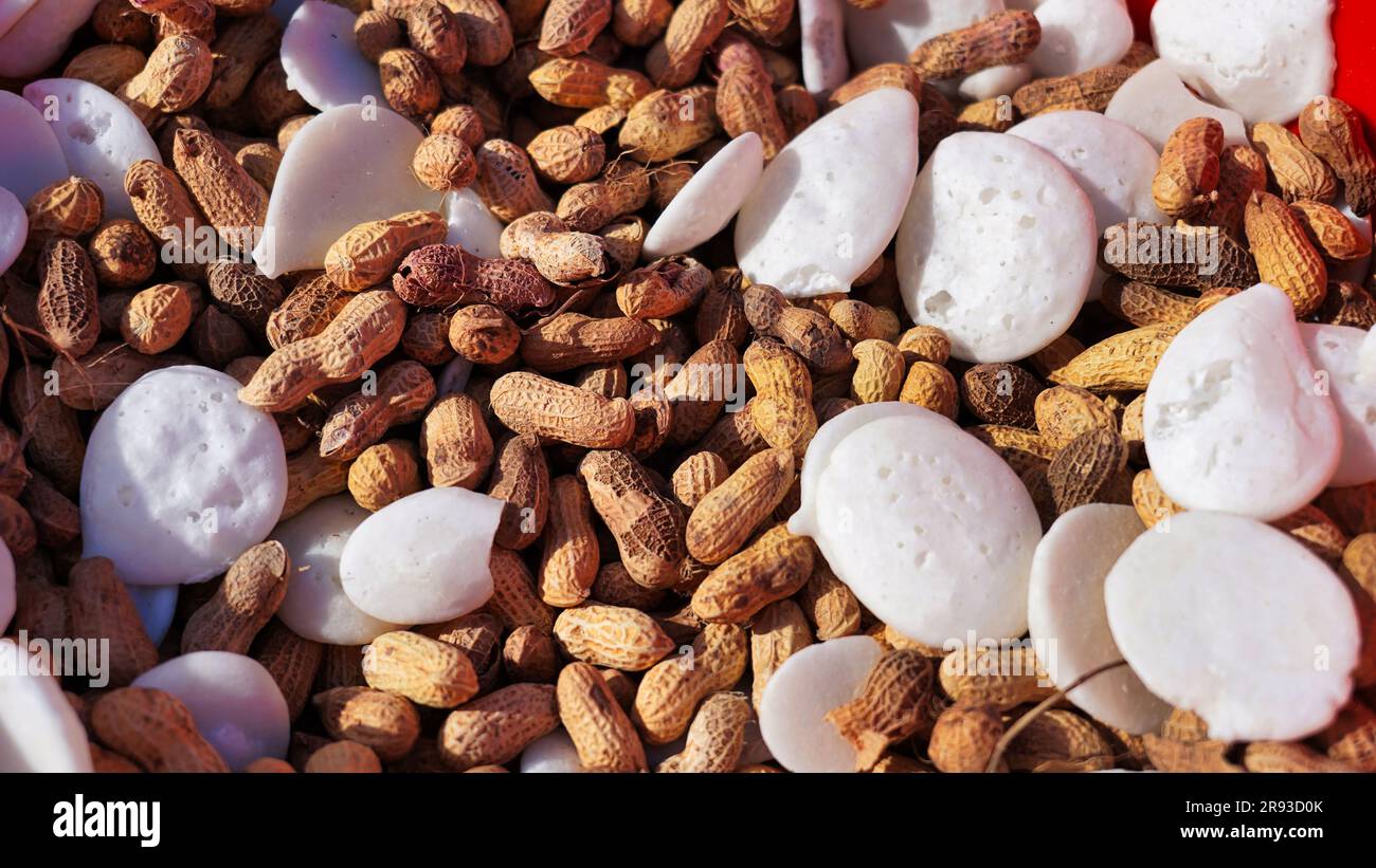 Gemahlene Nüsse oder Erdnüsse und Batasha oder Chilaka Perlu oder Hollow Sugar Cake ist ein aus Zuckersiruptropfen hergestelltes, beliebtes Hindu-Essen, das angeboten wird Stockfoto