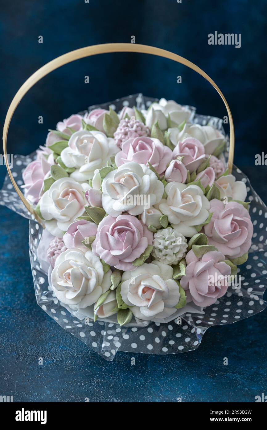 Zephyr-Blumenstrauß in einer Geschenkbox auf blauem Hintergrund. Stockfoto