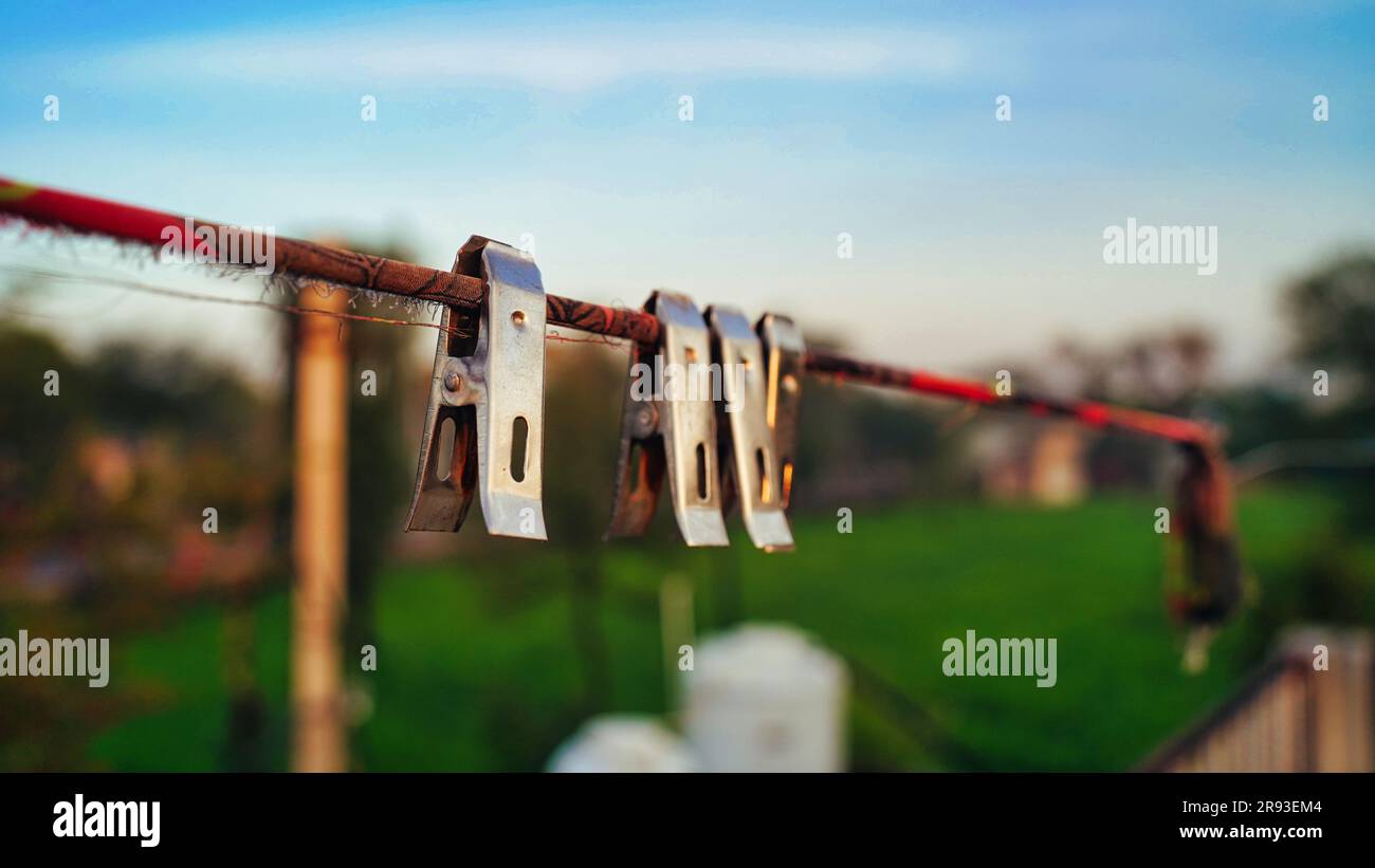 Nahaufnahme von Klamotten auf dem Dach, Klamotten an einem Seil. Einfarbige Kleiderbügel oder Stoffbügel aus Edelstahl Hängeklemmen. Selektiver Fokus. Stockfoto