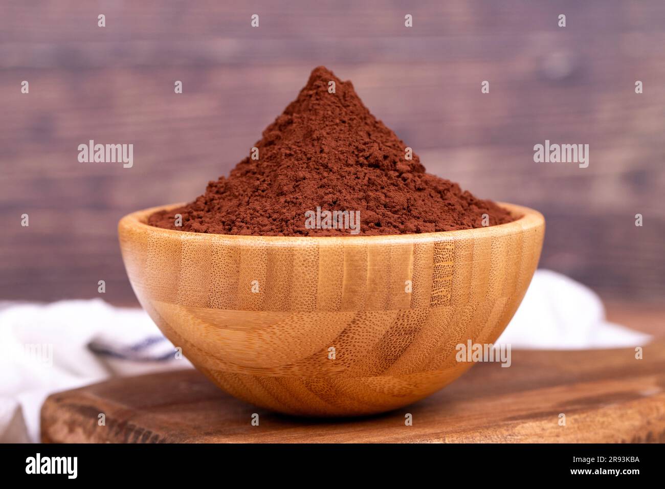Kakaopulver auf Holzhintergrund. Kakaopulver in Holzschüssel Stockfoto