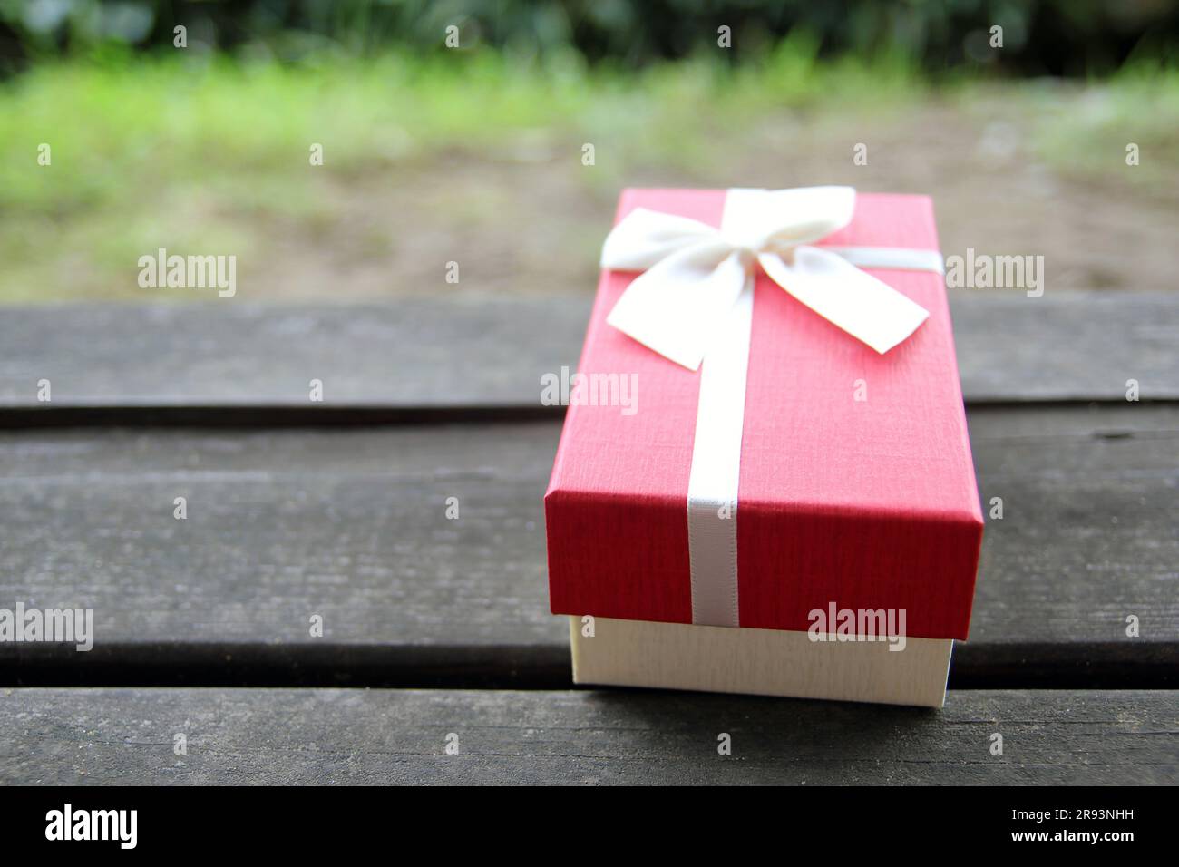 Verschiedene Geschenkboxen mit Sonnenlicht auf dem Rasen des Parks an einem sonnigen Sommertag Stockfoto