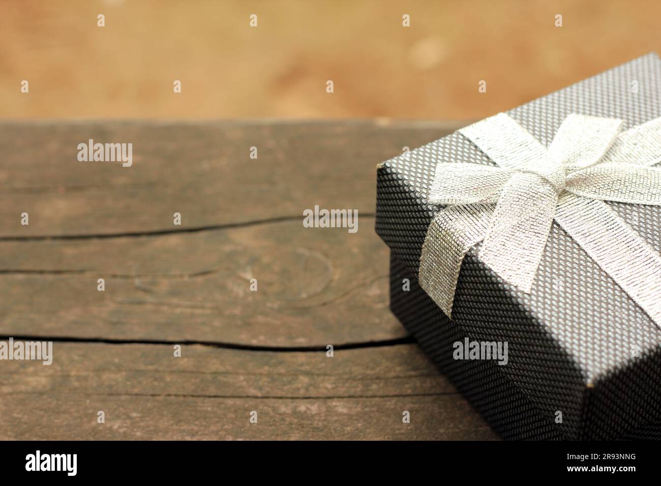 Verschiedene Geschenkschachteln mit Sonnenlicht auf dem Rasen des Parks an einem sonnigen Sommertag:Schachtel für Geschenk mit goldenem Band auf dem Holztisch Stockfoto
