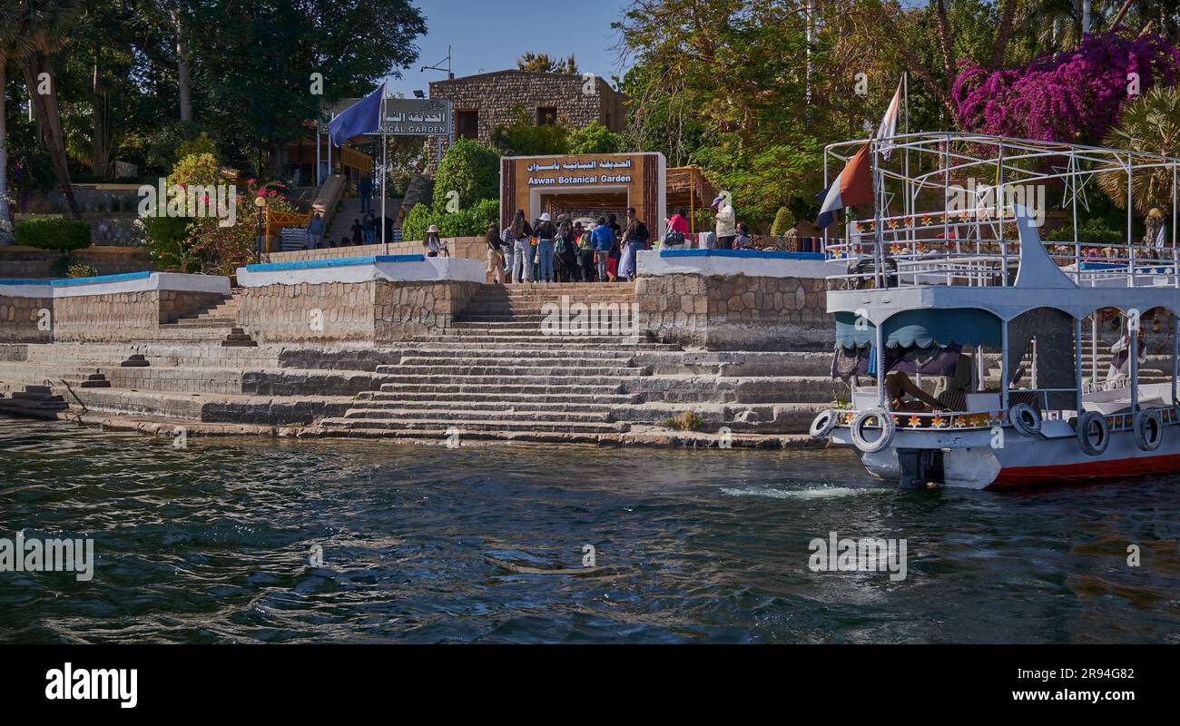Nil in Assuan, Ägypten Nachmittagsaufnahme mit Felukken und Booten im Fluss vor dem Eingang zum Botanischen Garten von Assuan Stockfoto