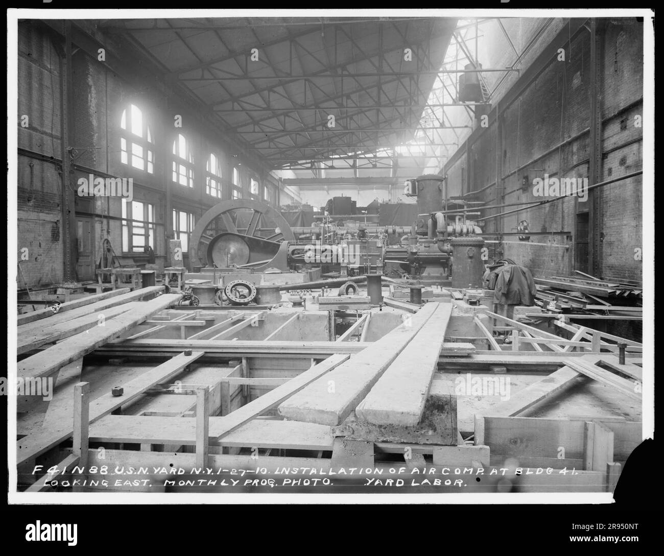 Installation eines Luftkompressors in Gebäude 41, Looking East, Monthly Progress Photo, Yard Labor. Glasplatten-Negative für den Bau und die Reparatur von Gebäuden, Einrichtungen und Schiffen am New York Navy Yard. Stockfoto