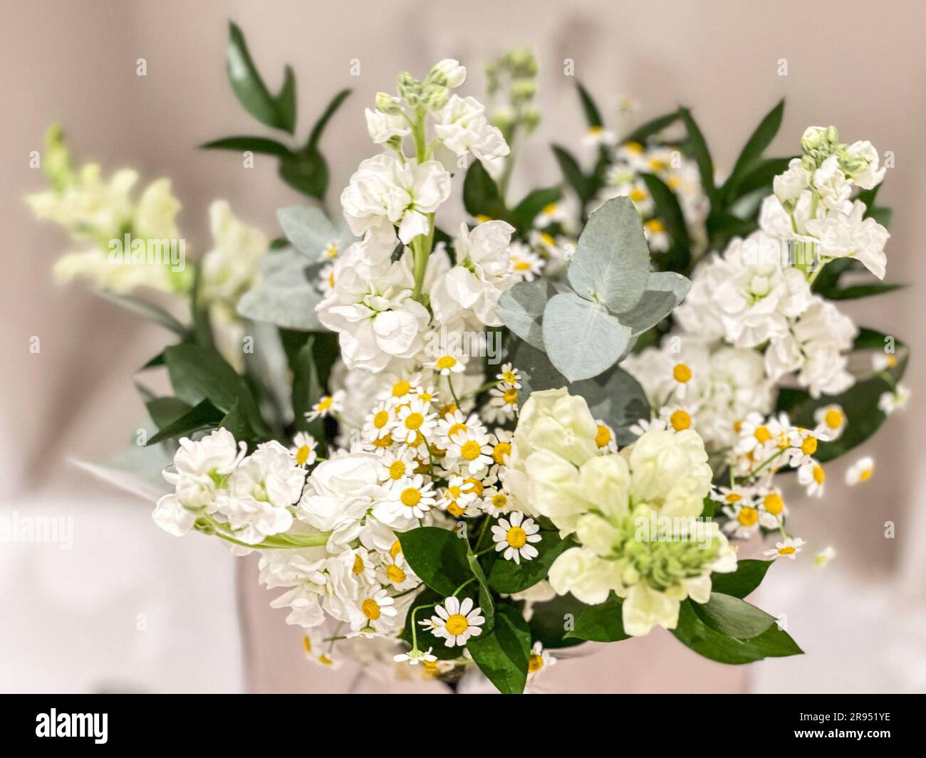 Ein handgebundener Blumenstrauß in einer Kartentasche, der in einem häuslichen Kamin ruht. Stockfoto