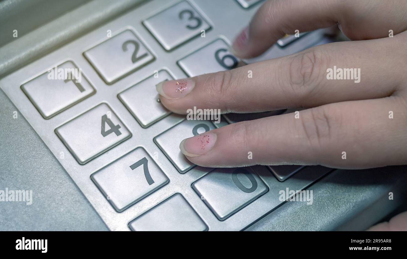 Die Hand einer Frau drückt Zahlen auf dem Tastenfeld, um den Verifizierungscode bei einer Finanztransaktion einzugeben. Stockfoto