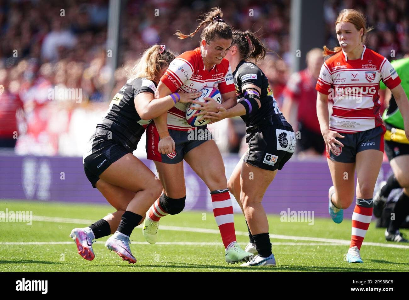 Rachel Lund (Zentrum) von Gloucester-Hartpury wird während des Finales der Allianz Premier 15s im Kingsholm-Stadion in Gloucester von Claudia MacDonald der Exeter Chiefs und Ellidh Sinclair der Exeter Chiefs angegriffen. Foto: Samstag, 24. Juni 2023. Stockfoto