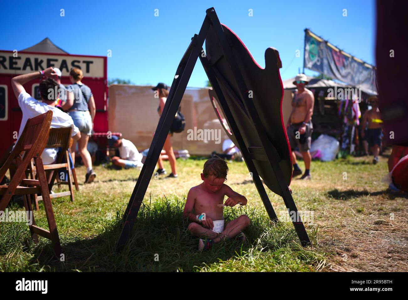 Anton Gatley, 4 Jahre alt, aus Devon im Schatten während des heißen Wetters beim Glastonbury Festival auf der Worthy Farm in Somerset. Foto: Samstag, 24. Juni 2023. Stockfoto