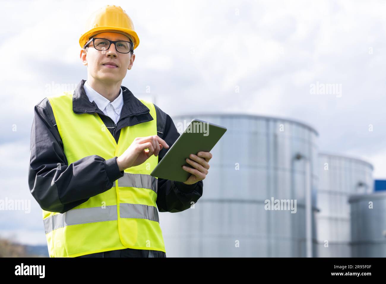 Ingenieur mit digitalem Tablet auf einem Hintergrund von Gastanks Stockfoto