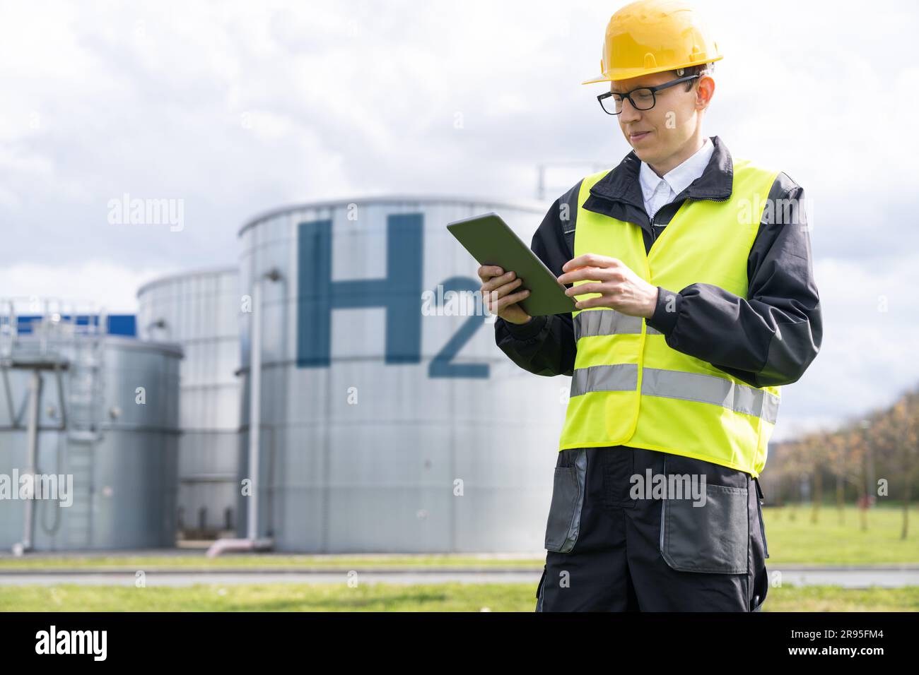 Ingenieur mit Tablet-Computer im Hintergrund der Wasserstofffabrik. Hochwertiges Foto Stockfoto