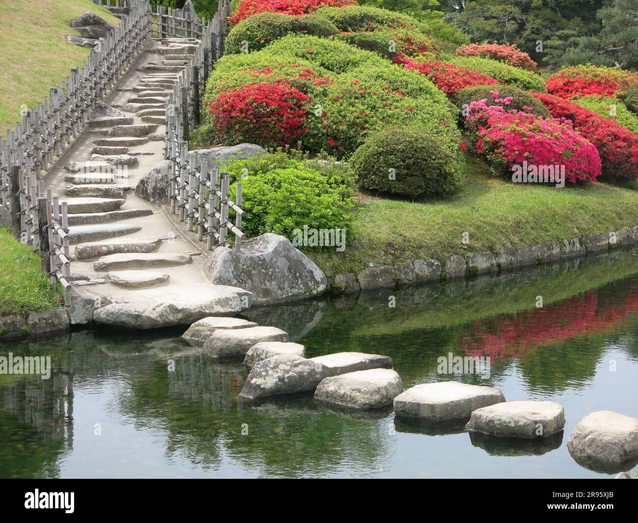 Korakuen ist einer der drei schönsten Landschaftsgärten Japans und ein Garten mit Steinen zum Überqueren des Sees. Stockfoto