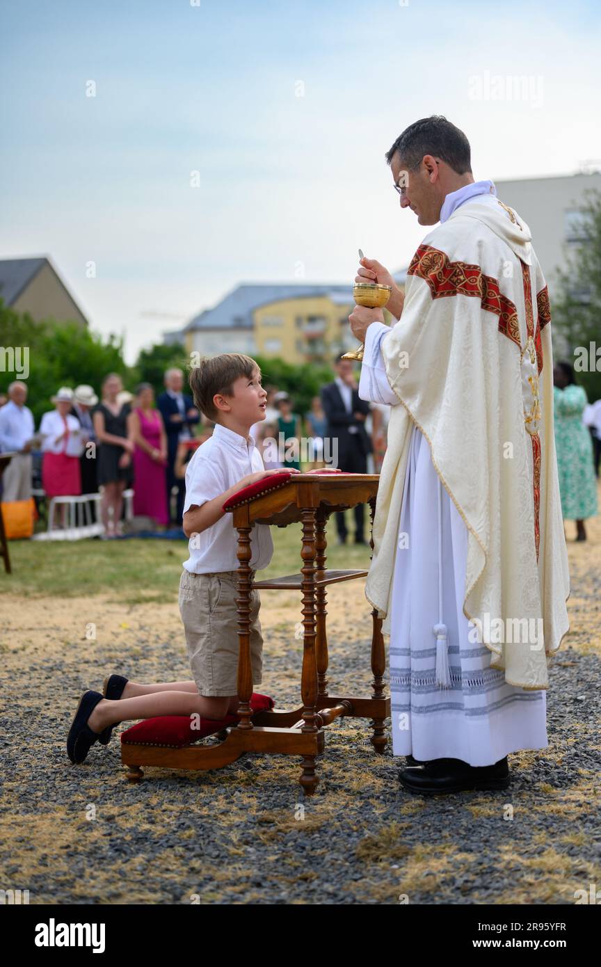 Ein Kind, das die erste Heilige Kommunion erhält. Stockfoto