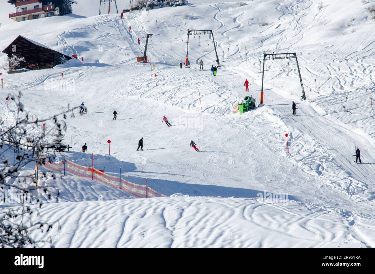 Eine Nahaufnahme einer Gruppe von Wintersportfans, die in Österreich Alpinski und Snowboarden betreiben Stockfoto
