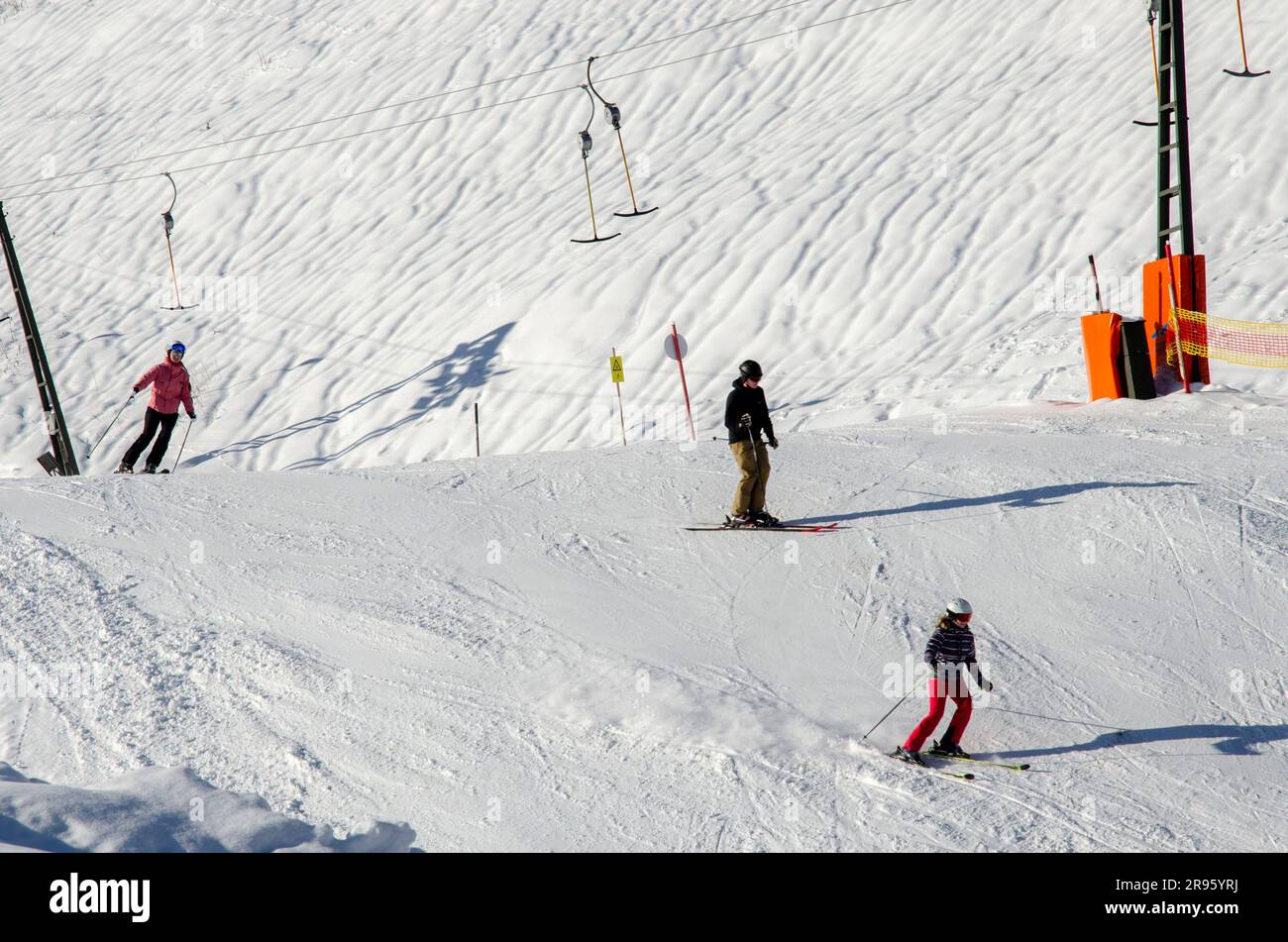 Eine Nahaufnahme einer Gruppe von Wintersportfans, die in Österreich Alpinski und Snowboarden betreiben Stockfoto