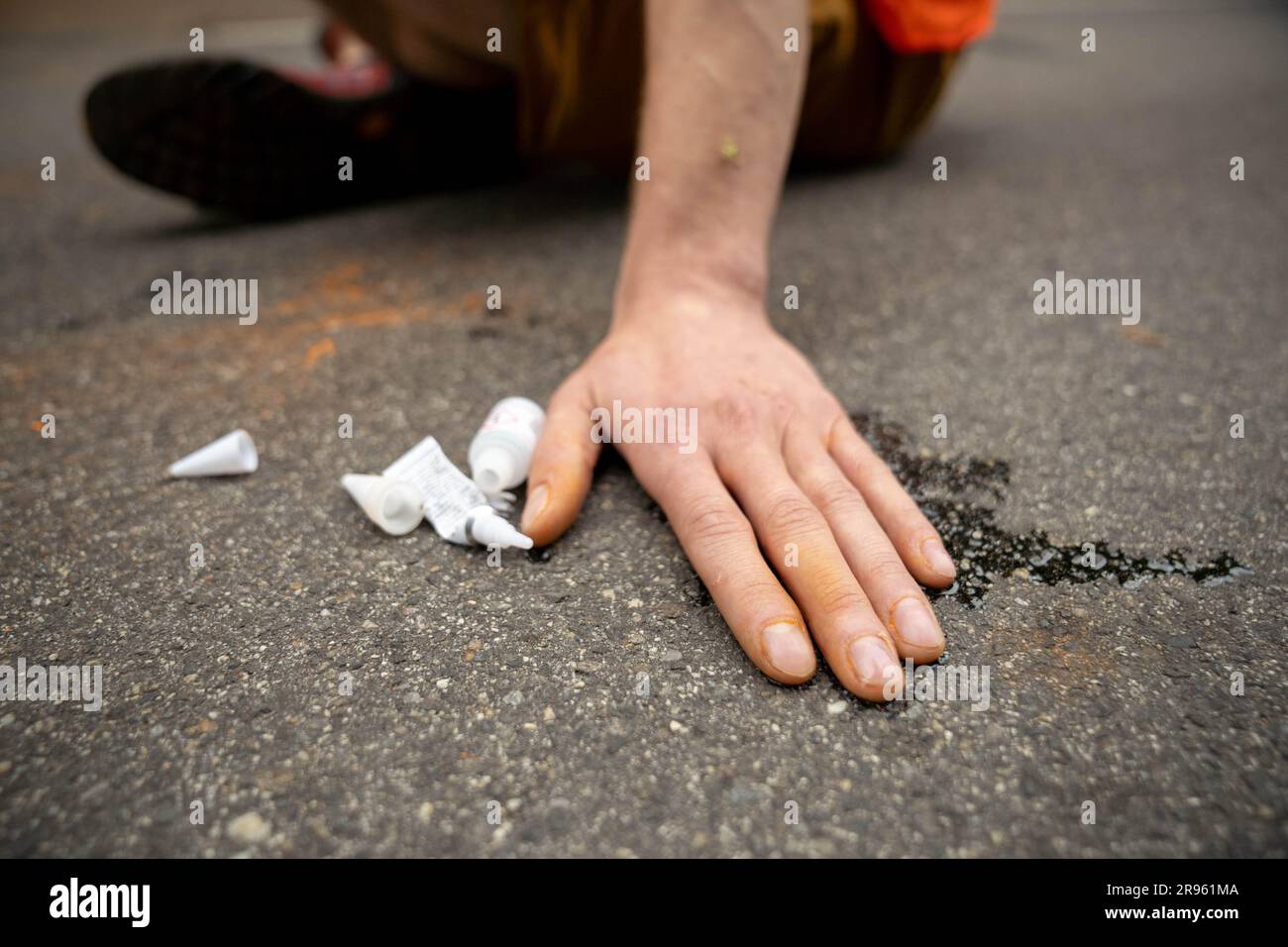 Stift Göttweig/Furth bei Göttweig, Österreich. 24. Juni 2023 Klimaaktivist der Gruppe Last Generation Austria "Letzte Generation Österreich", auf die Straße geklebt, blockiert den Konvoi des bulgarischen Präsidenten und angeblich des österreichischen Kanzlers Karl Nehammer nach einem europäischen Gipfel im Schloss. ©Andreas Stroh Stockfoto