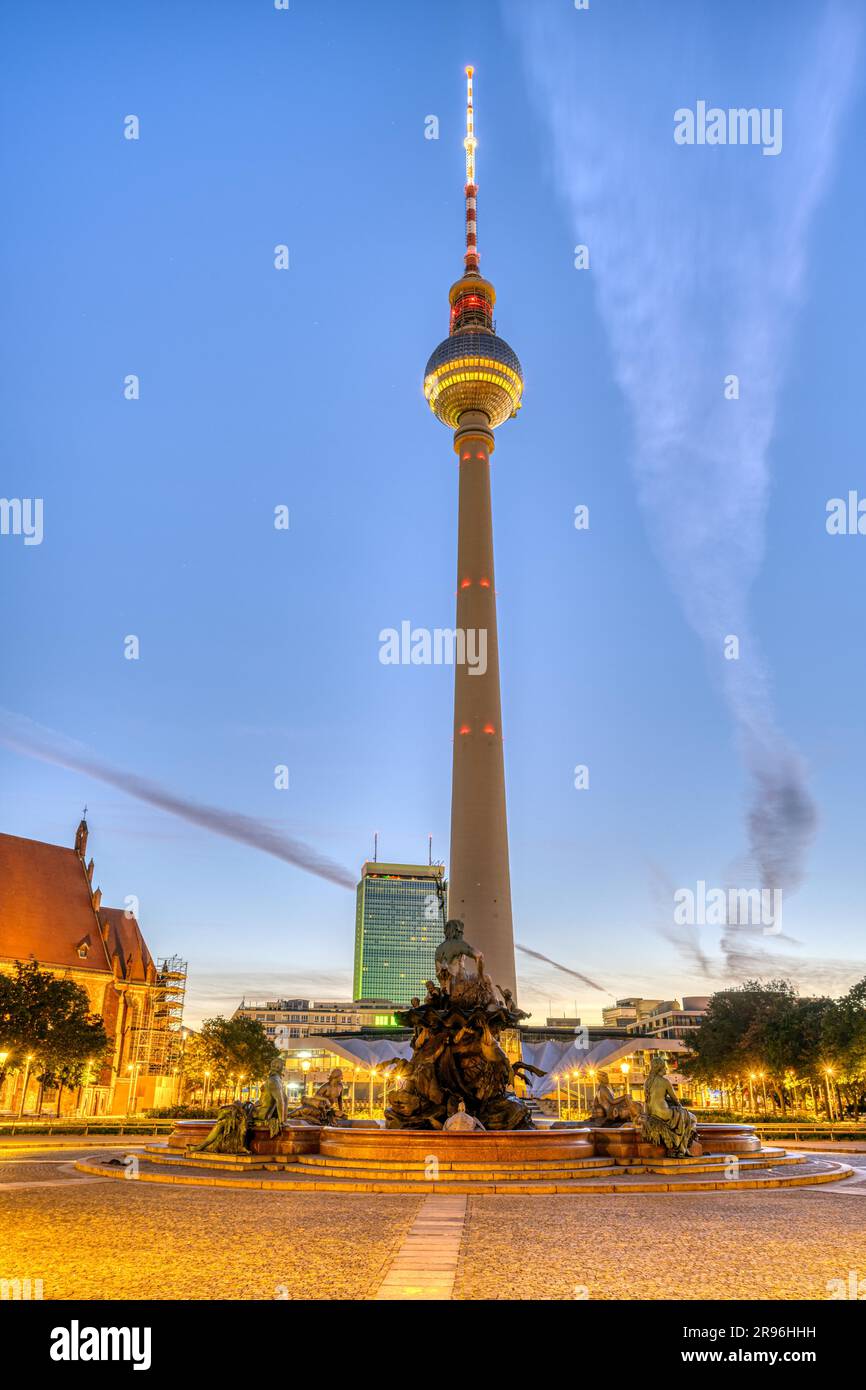 Der berühmte Berliner Fernsehturm mit dem Neptunbrunnen vor Sonnenaufgang Stockfoto