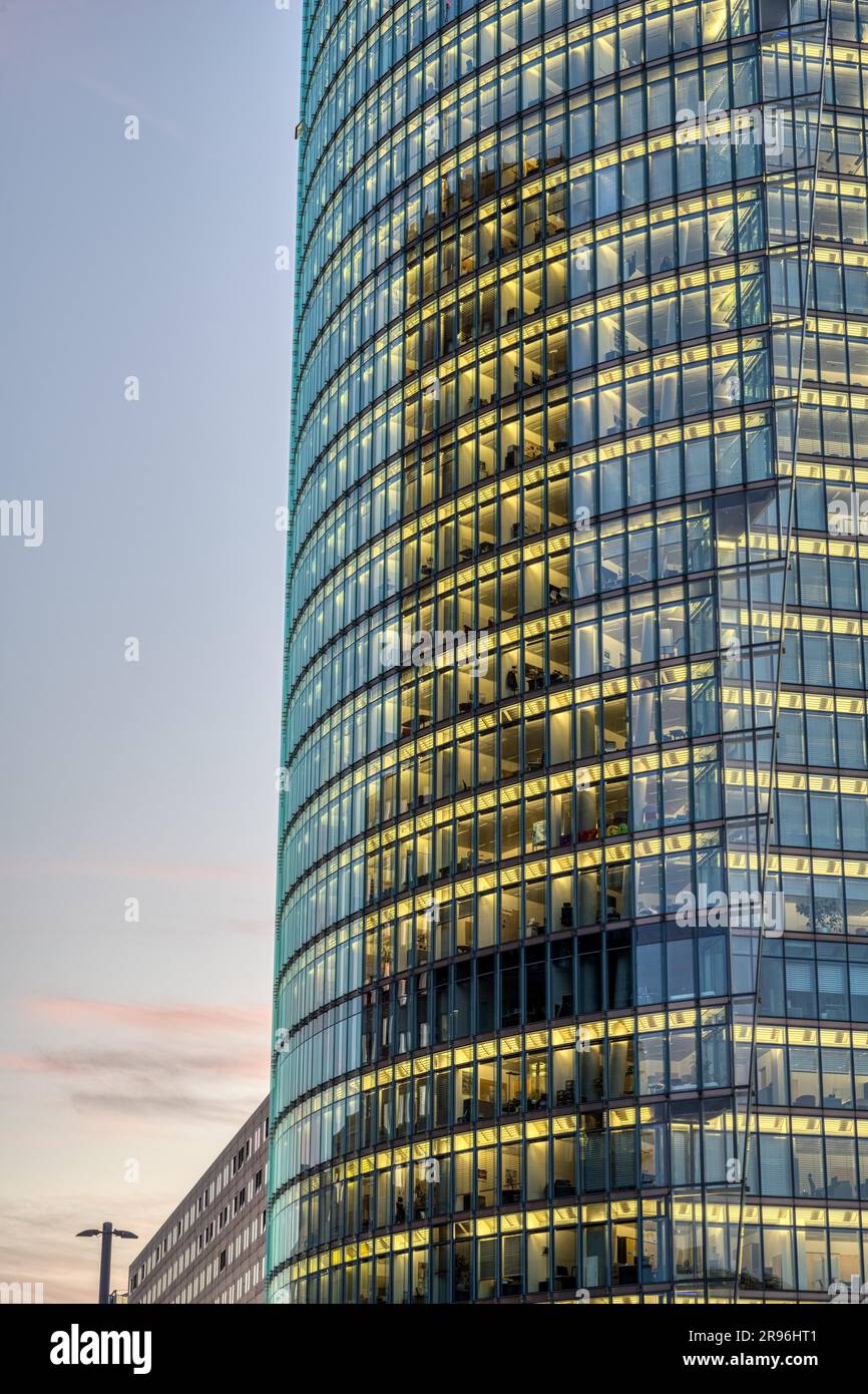 Detail eines hohen Bürogebäudes mit beleuchteten Fenstern in der Abenddämmerung Stockfoto