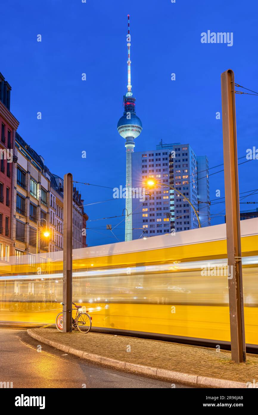 Der berühmte Fernsehturm in Berlin bei Nacht mit einer bewegenden Straßenbahn Stockfoto