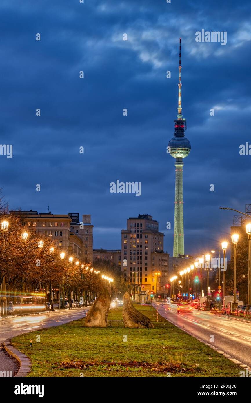 Der berühmte Berliner Fernsehturm mit Karl-Marx-Allee bei Nacht Stockfoto