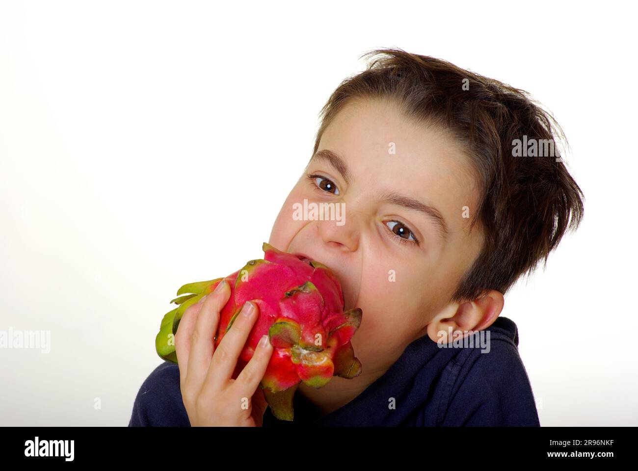 Der Junge beißt in dreieckigen Hylocereus (Hylocereus triangularis), Kaktusfrucht, Drachenfrucht, Pitaya Stockfoto