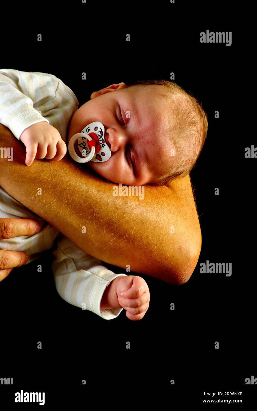 Baby auf dem Arm des Vaters, Baby, Schnuller, Puppe Stockfoto