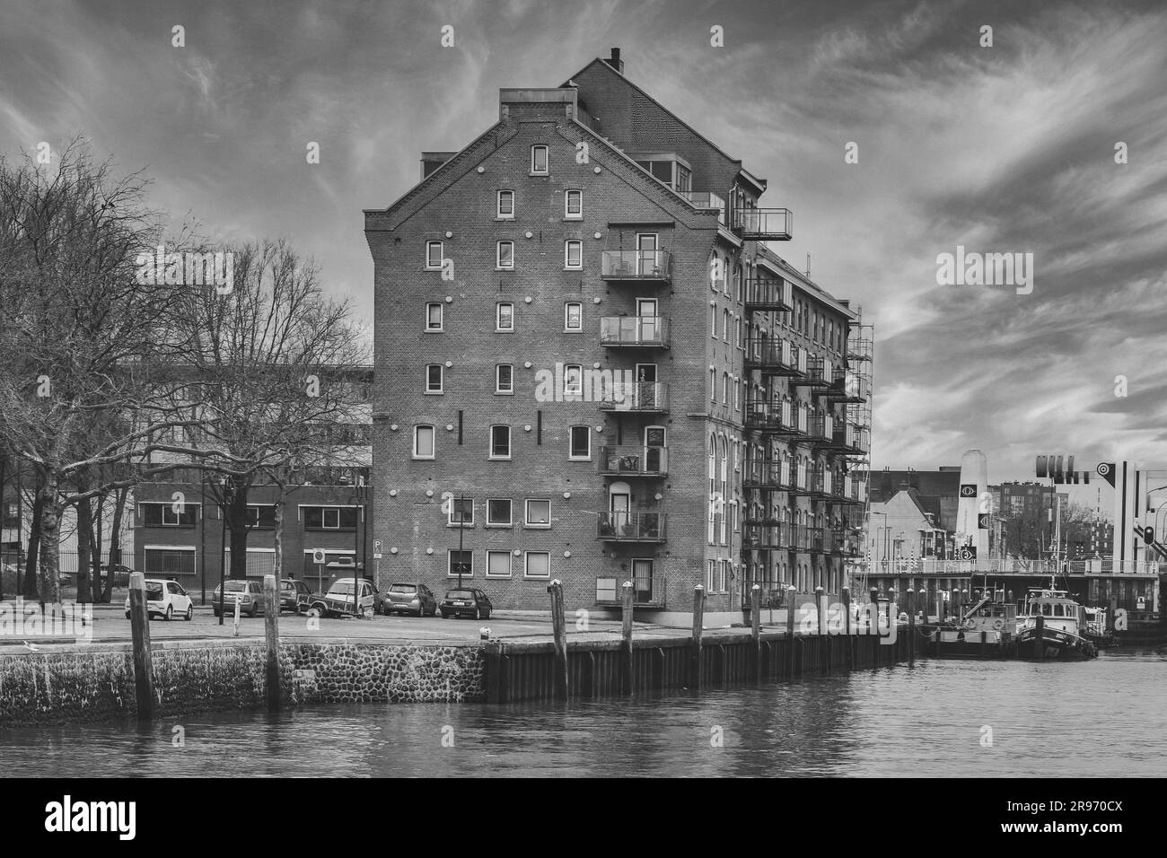 Ein altes, verlassenes Gebäude mit einem dramatischen Schwarz-Weiß-Farbschema in der Nähe eines Wassers Stockfoto