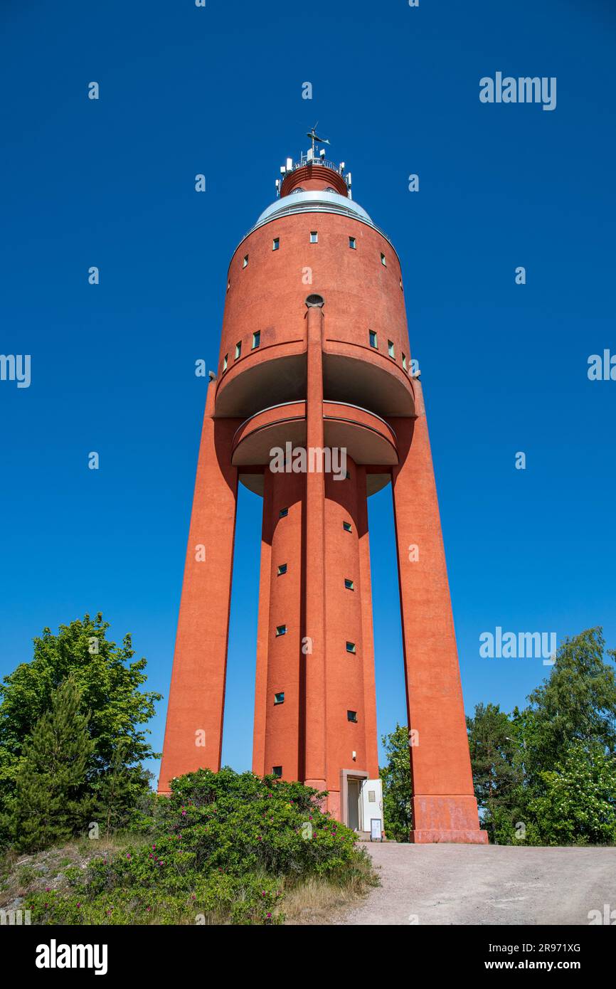 Blick aus dem niedrigen Winkel auf einen roten Wasserturm, der von Bertel Liljequist entworfen und 1943 erbaut wurde, vor dem klaren blauen Himmel an einem sonnigen Sommertag in Hanko, Finnland Stockfoto