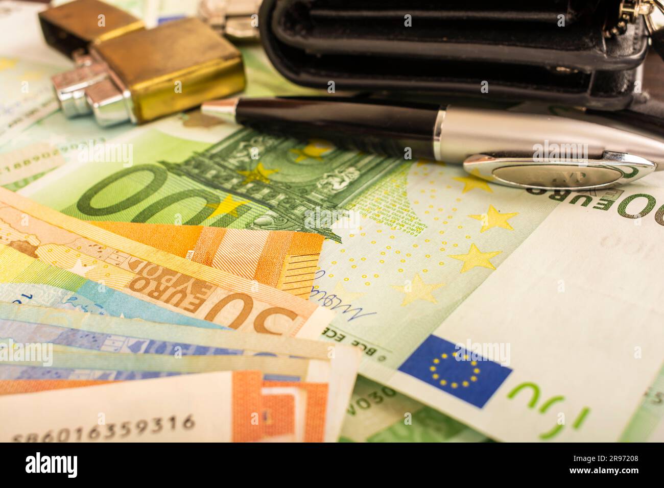 Goldener Feuerzeugwecker auf dem Hintergrund von grünem Geld 100-Euro-Scheine Stockfoto