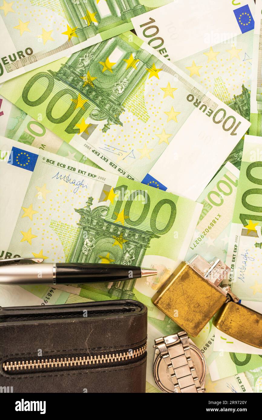 Goldener Feuerzeugwecker auf dem Hintergrund von grünem Geld 100-Euro-Scheine Stockfoto