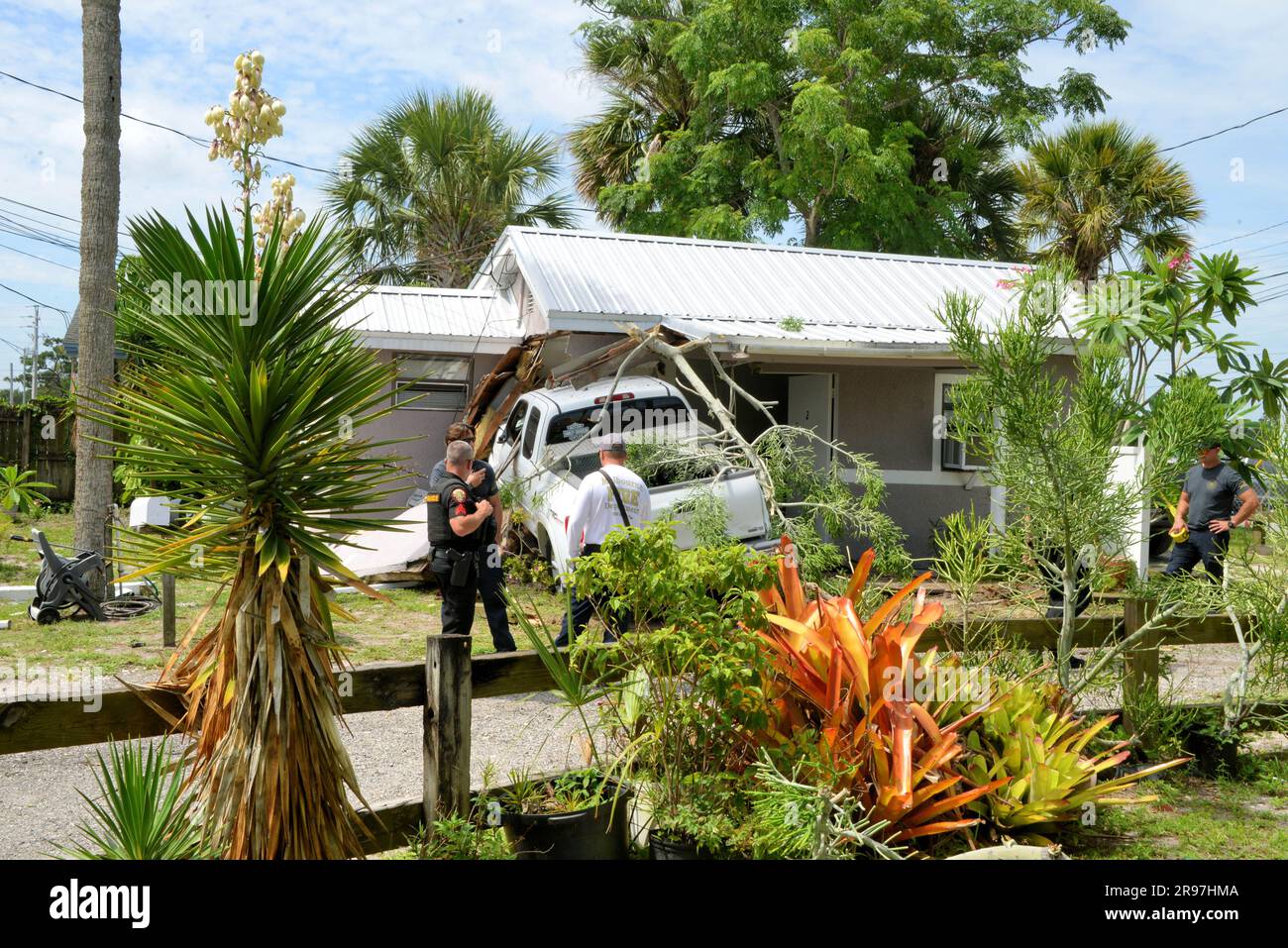 Melbourne, Brevard County, Florida, USA. 24. Juni 2023. Beschrieben von Zeugen eines Verkehrsunfalls, der die Anstifter Toyota Pickup Truck über eine fünfspurige Hauptstraße, Bürgersteig, Hof schickte, eine Straßenlaterne über eine Einfahrt zerstörte und schließlich in ein Haus stürzte. Es wurden keine Verletzungen gemeldet und der städtische Bauinspektor wurde gerufen, Florida Power & Light hat die Stromversorgung unterbrochen. Kredit: Julian Leek/Alamy Live News Stockfoto