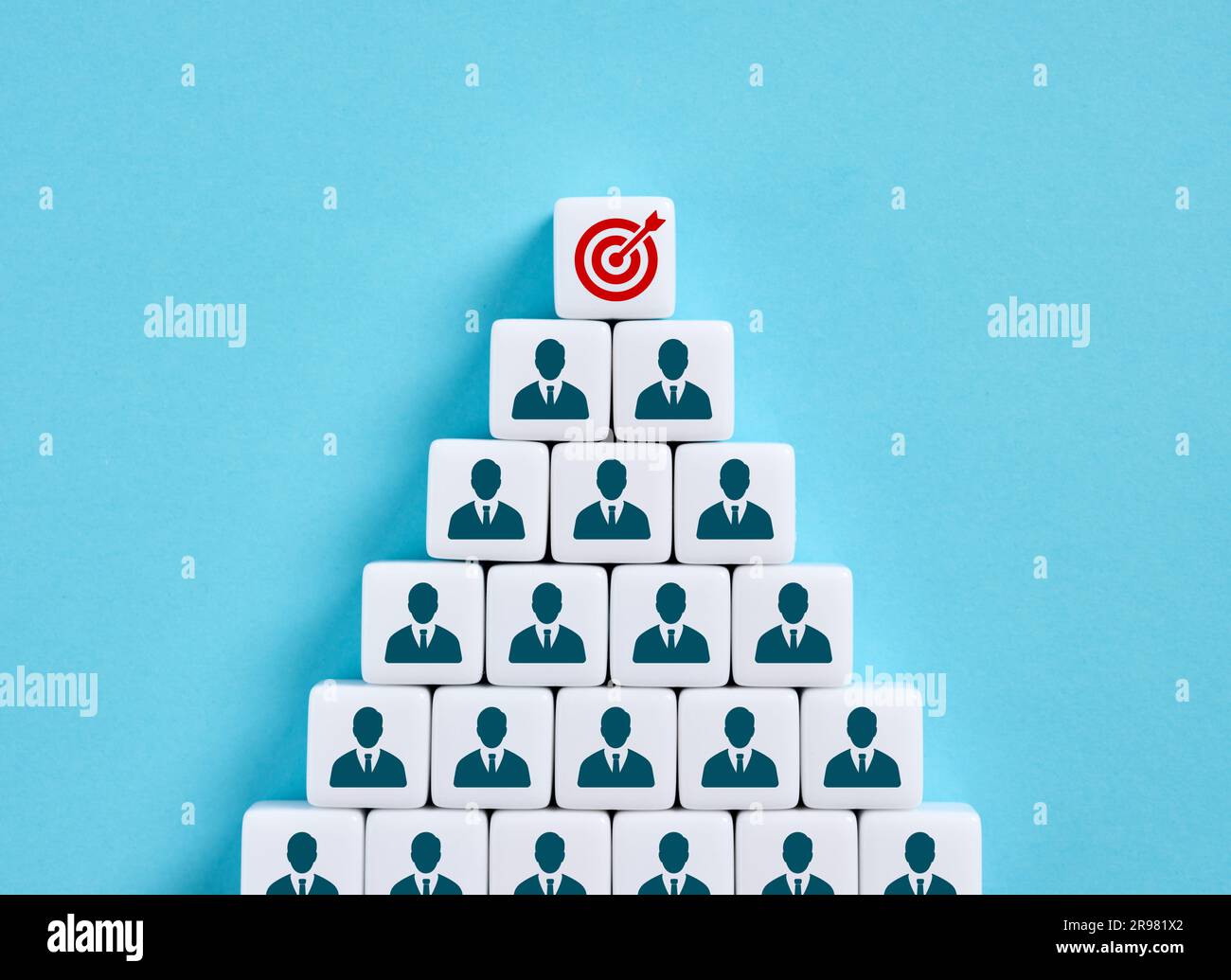Teamarbeit, um die Geschäftsziele zu erreichen. Festlegung von Unternehmenszielen. Gemeinsame Verantwortung, um die Zielvorgaben zu erreichen. Kubenpyramide mit Angestelltem Stockfoto