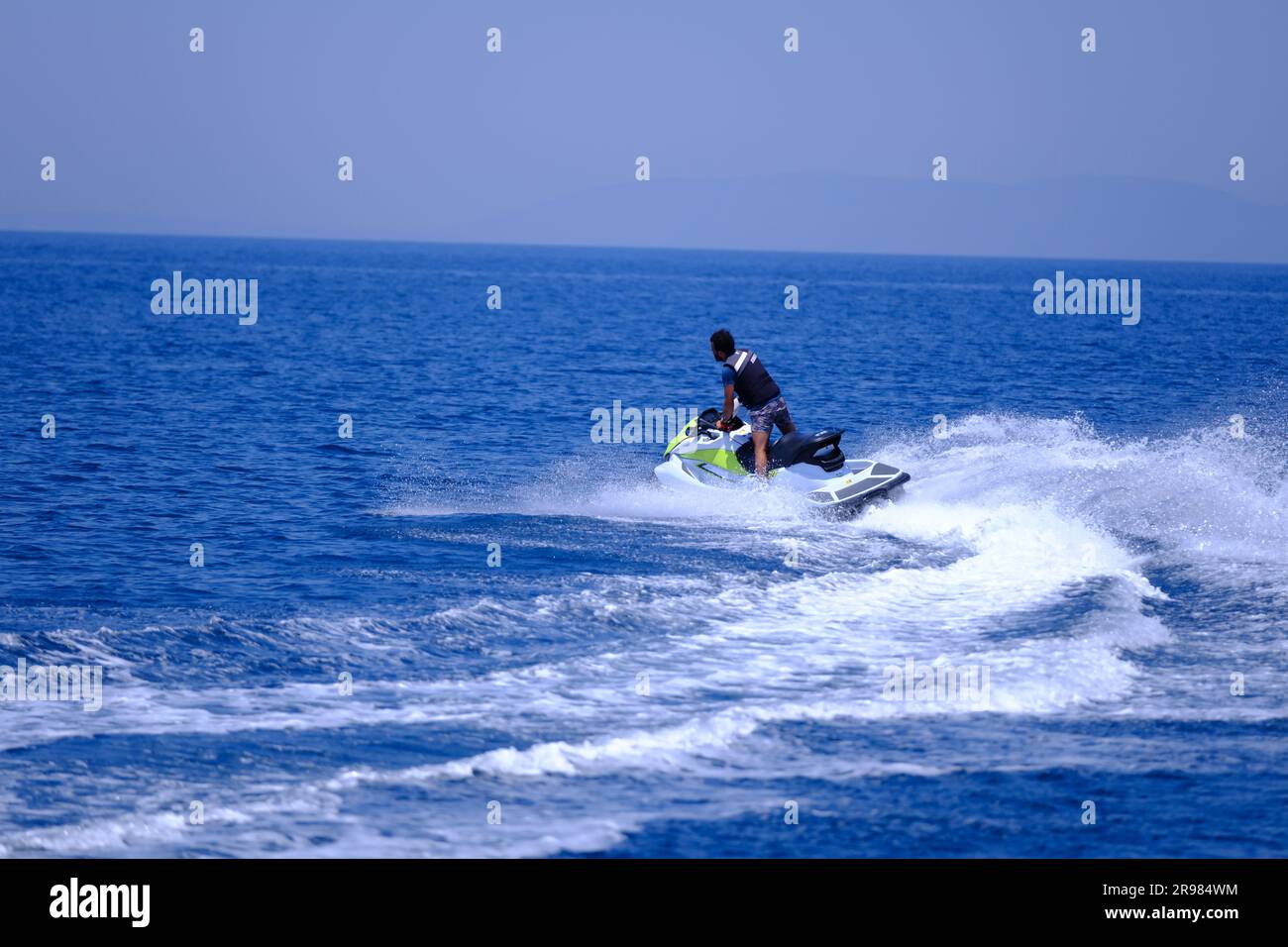 Junger Mann mit Bart Jet-Ski fahren an einem sonnigen Sommertag Stockfoto