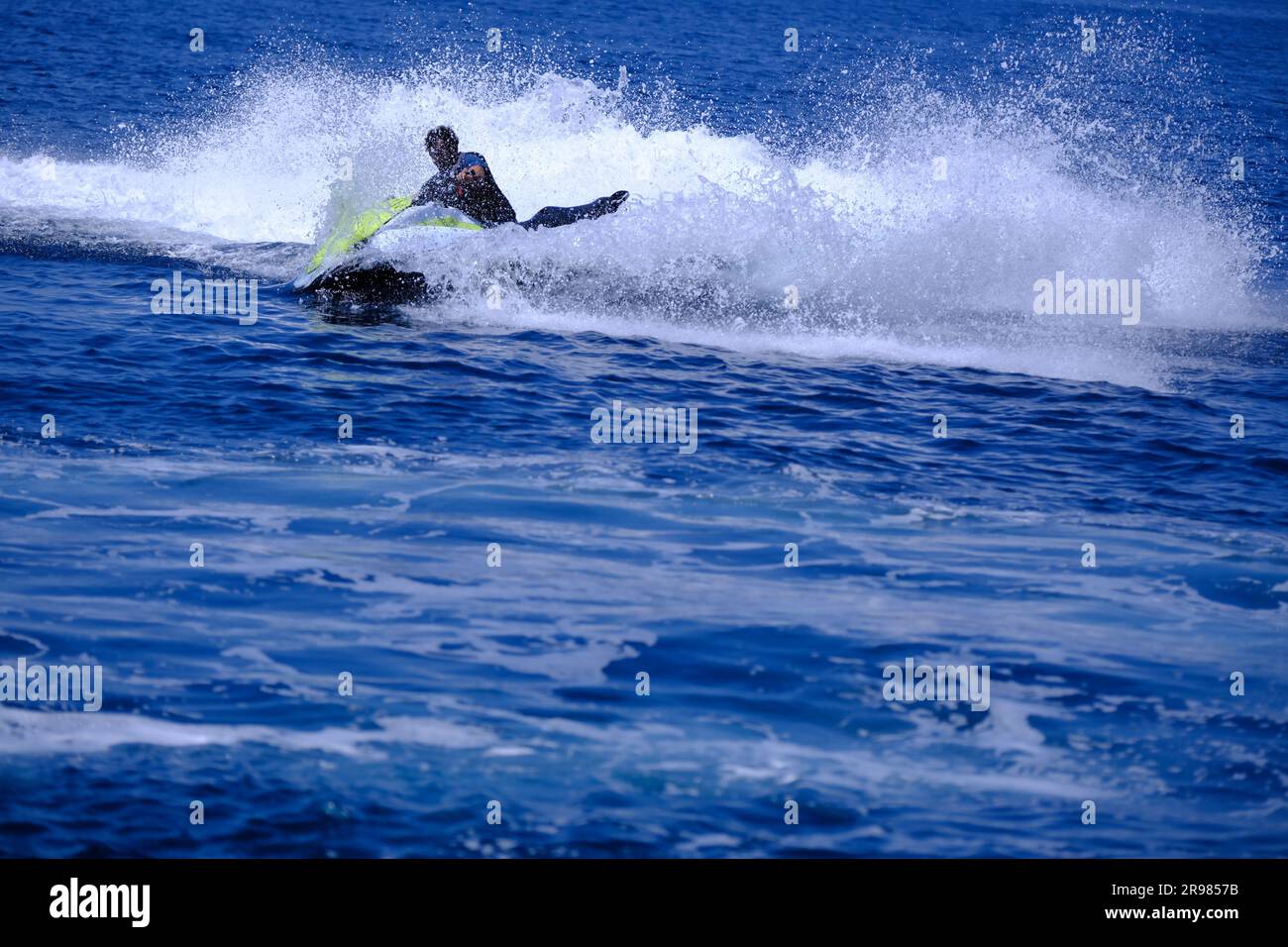 Junger Mann mit Bart Jet-Ski fahren an einem sonnigen Sommertag Stockfoto