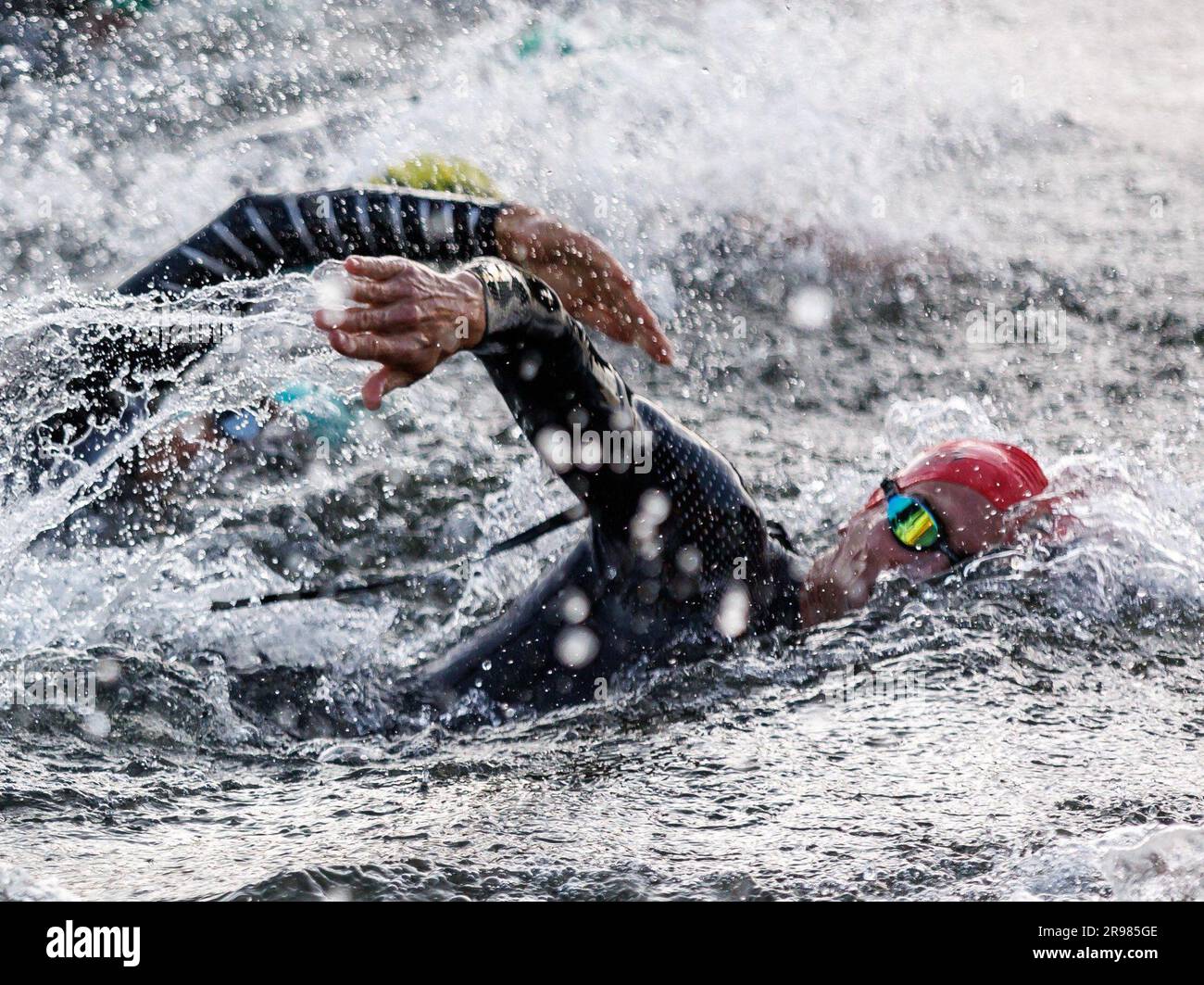 Hilpoltstein, Deutschland. 25. Juni 2023. Adrew Starykowicz (R, Red Cap) Triathlet aus den USA beginnt mit anderen Triathleten während des Schwimmens bei der Datev Challenge Roth. Teilnehmer des Triathlons müssen 3,8 km schwimmen, 180 km radeln und 42,195 km laufen Kredit: Daniel Karmann/dpa/Alamy Live News Stockfoto