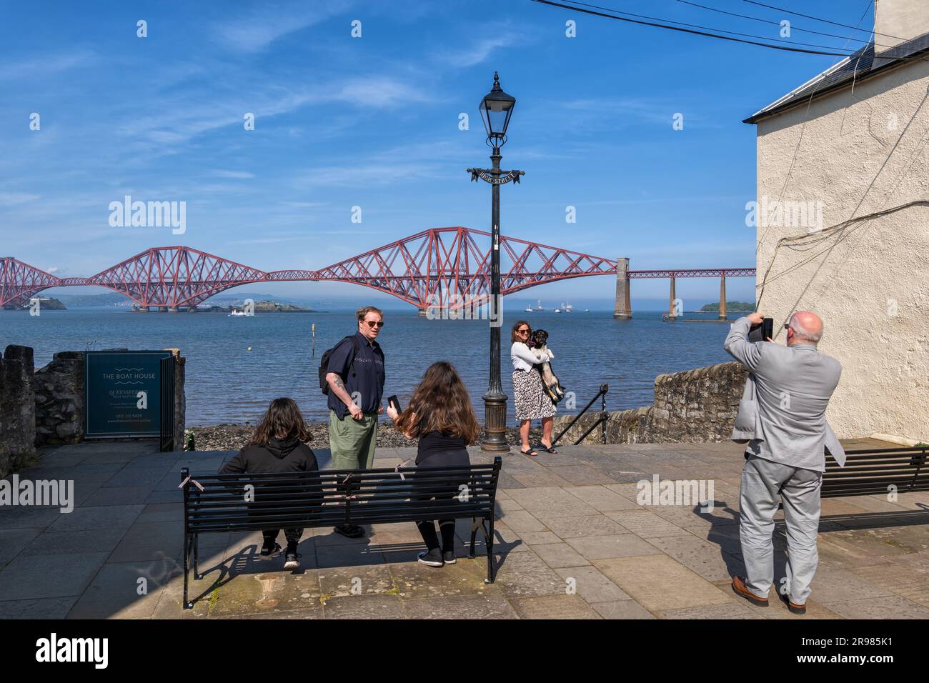 Leute, die Fotos von der Terrasse mit Blick auf die Forth Bridge in South Queensferry Town in Firth of Forth in Schottland, Großbritannien, machen. Stockfoto