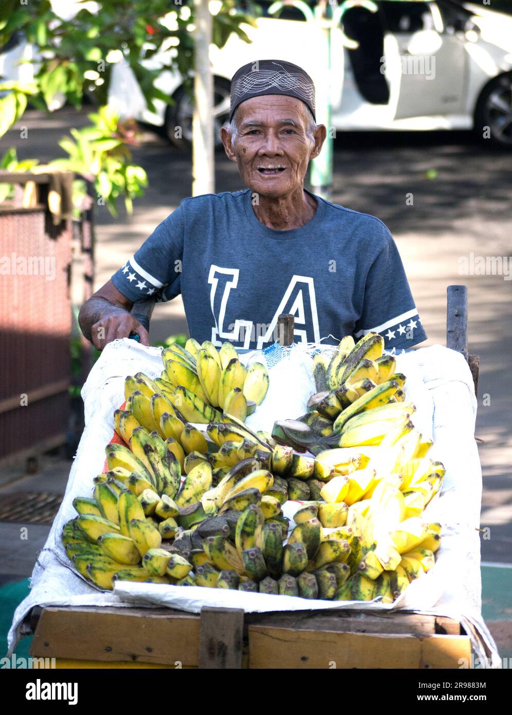 Jakarta, Indonesien - 20. Juni 2023 : Portriat asiatischer Senior man reist Bananenverkäufer auf dem Wagen lächelnd in die Kamera Stockfoto