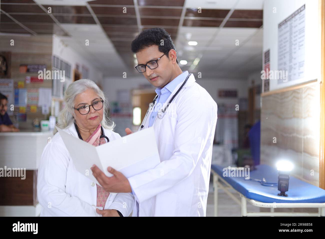 Ältere Ärztin und junge Ärztin. Arzt liest Patientenbericht auf Papieren oder ärztlichen Dokumenten. Stockfoto