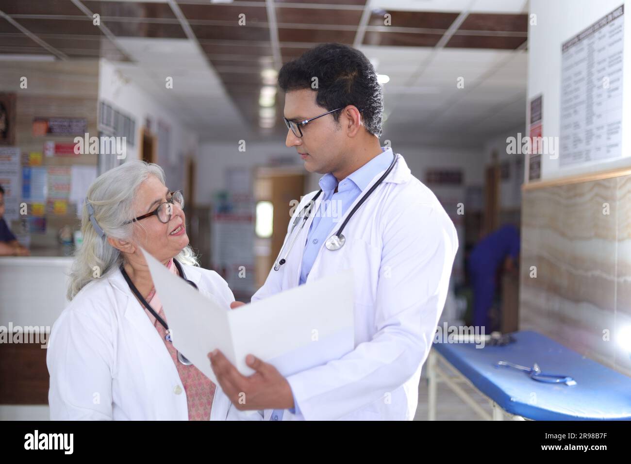 Ältere Ärztin und junge Ärztin. Arzt liest Patientenbericht auf Papieren oder ärztlichen Dokumenten. Stockfoto