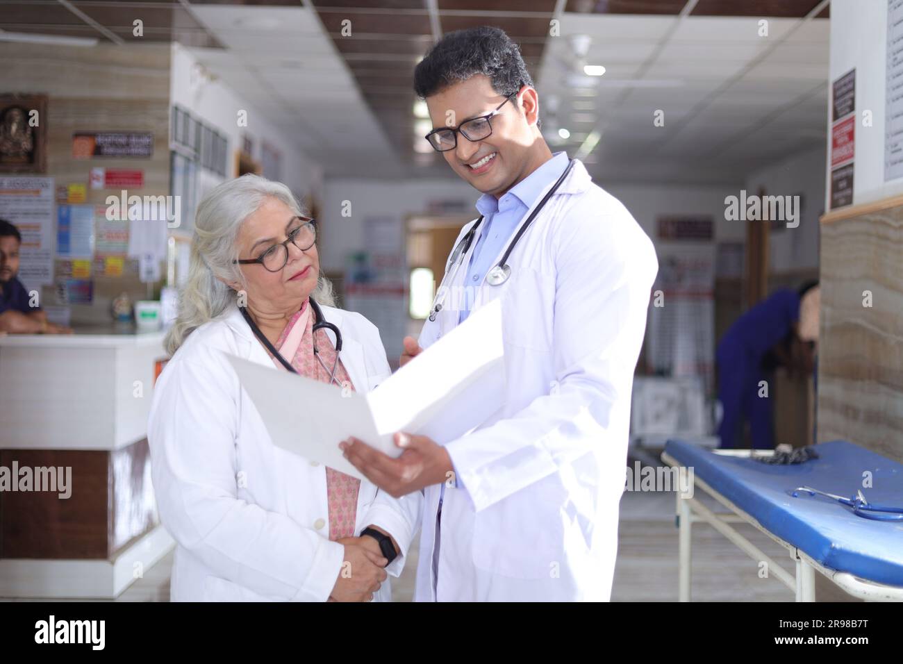 Ältere Ärztin und junge Ärztin. Arzt liest Patientenbericht auf Papieren oder ärztlichen Dokumenten. Stockfoto