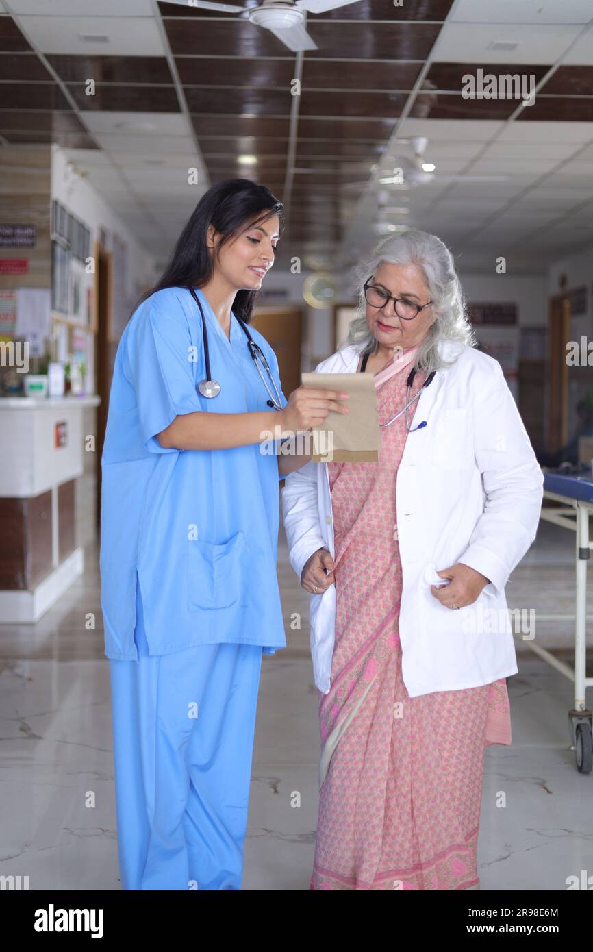 Ärzte besprechen den Patientenfallstatus mit seinem medizinischen Personal nach der Operation. Pharmazeutischer Vertreter mit ärztlichem Bericht. Stockfoto