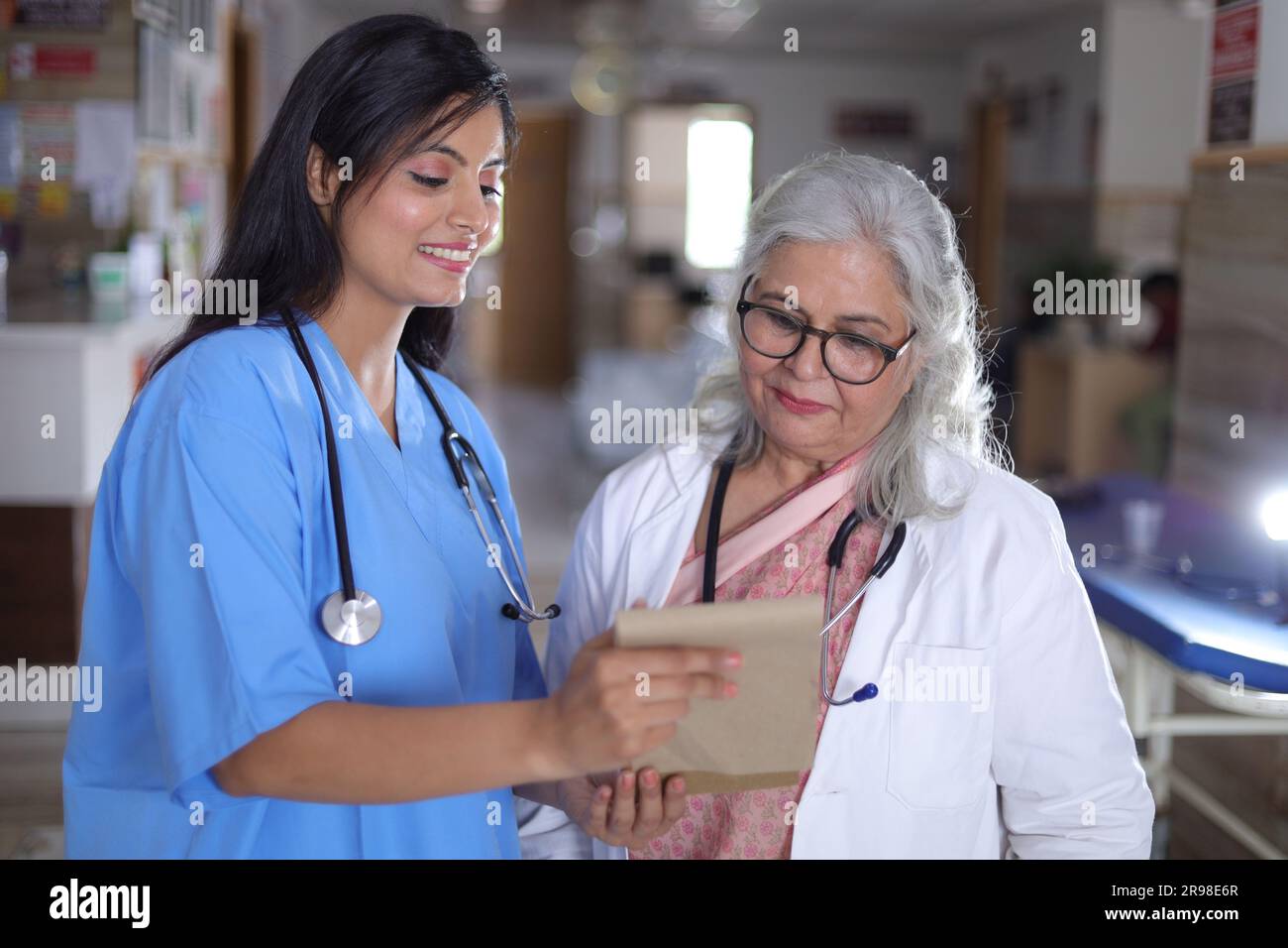 Ärzte besprechen den Patientenfallstatus mit seinem medizinischen Personal nach der Operation. Pharmazeutischer Vertreter mit ärztlichem Bericht. Stockfoto