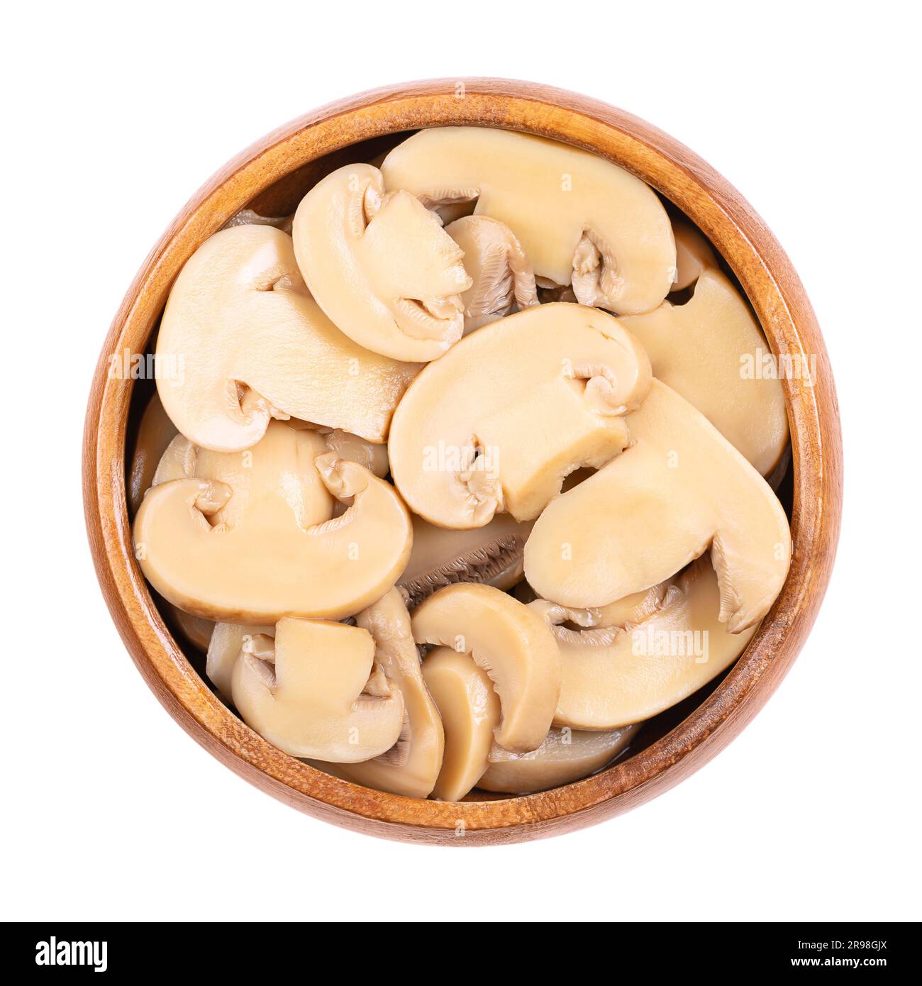 In Dosen geschnittene Champignon-Pilze in einer Holzschüssel. Agaricus bisporus, auch bekannt als gewöhnlicher, Button-, Kulturpilz oder Tafelpilz. Stockfoto