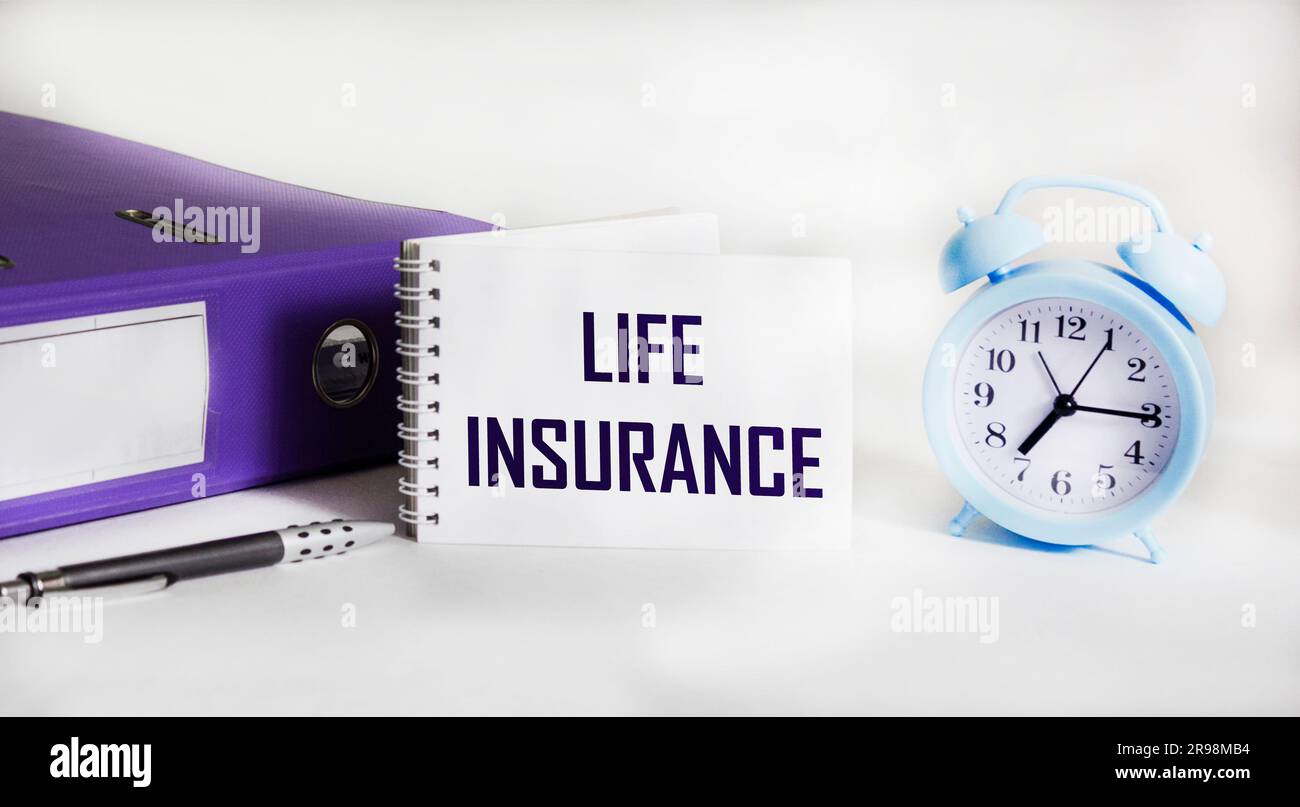 Lebensversicherungswort auf Notizblock mit Uhr und Ordner auf weißem Hintergrund Stockfoto