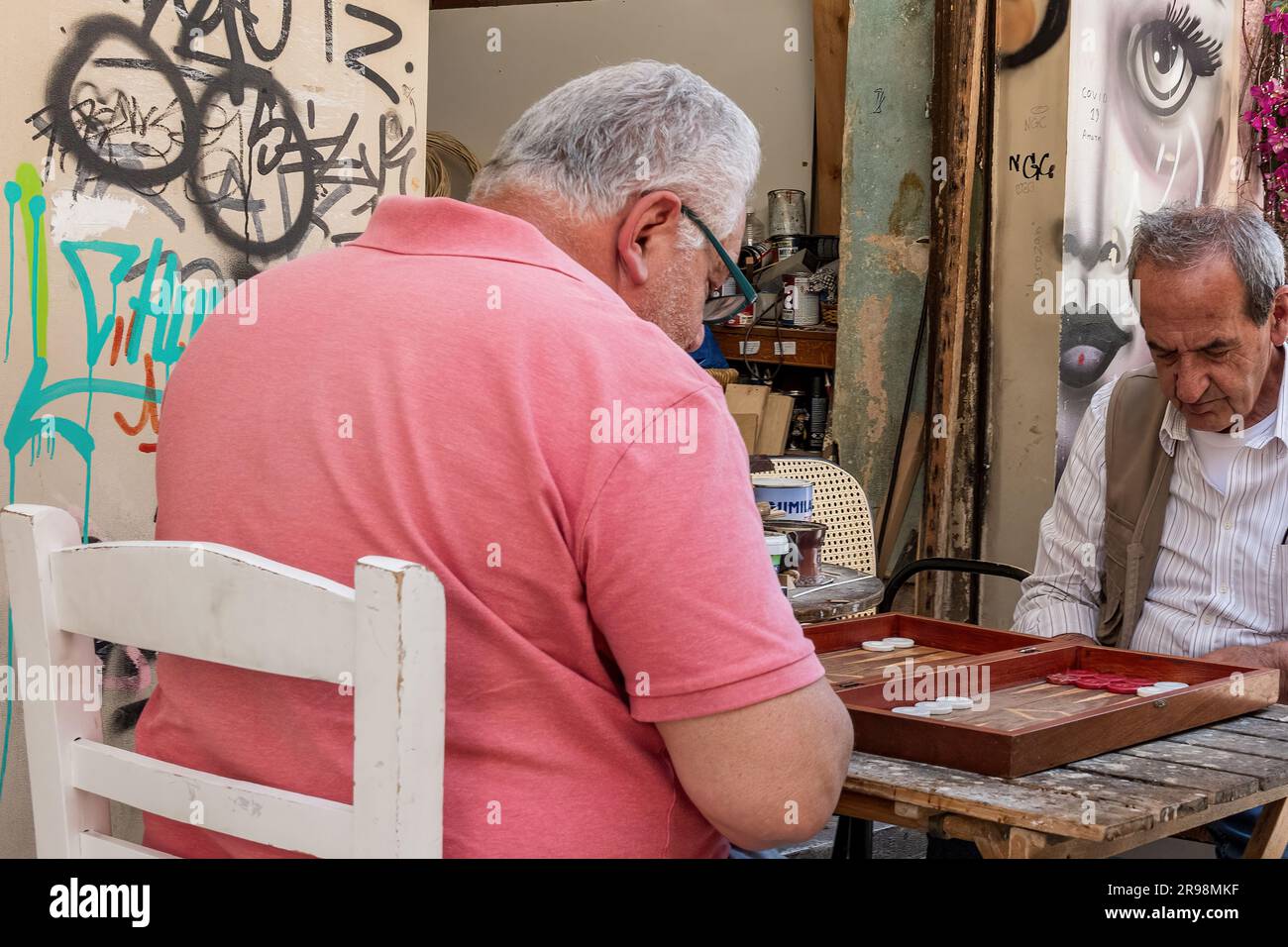 Zwei griechische Männer spielen Backgammon in einer Athener Straße. Stockfoto